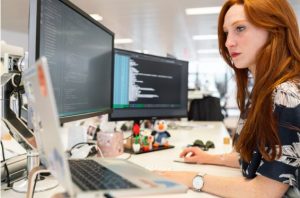 A woman in an office researching RFP automation on her computer